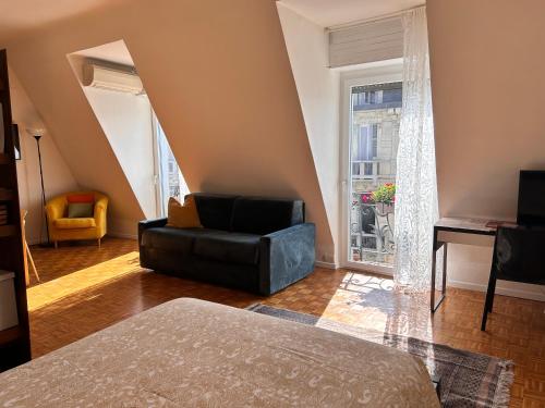 a living room with a black leather chair and a window at Easy Isola, for an easy stay in Milan