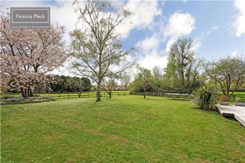 a park with a park bench in a grass field at A rural retreat with space and light in Birlingham