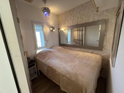 une chambre avec un lit et un grand miroir dans l'établissement 2 pièces, Port Nature 4 coursives, vue mer, face au Waïki, au Cap d'Agde