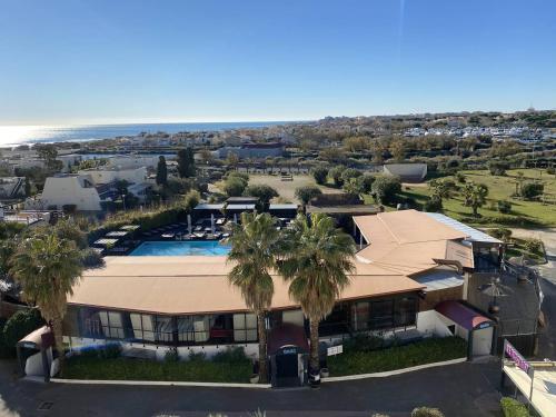 - une vue aérienne sur une maison avec une piscine et des palmiers dans l'établissement 2 pièces, Port Nature 4 coursives, vue mer, face au Waïki, au Cap d'Agde