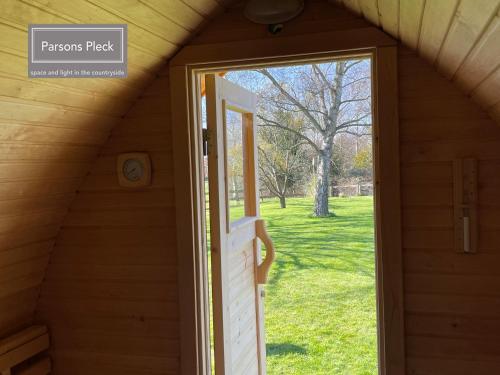 an open door of a wooden house with a window at A rural retreat with space and light in Birlingham