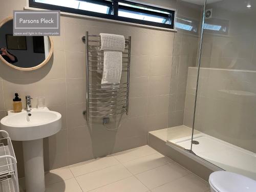 a bathroom with a shower and a sink and a toilet at A rural retreat with space and light in Birlingham