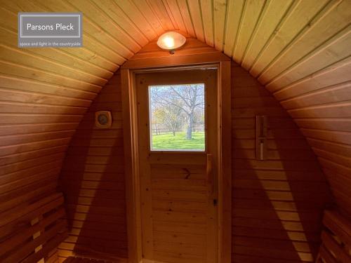 an attic room with a door and a window at A rural retreat with space and light in Birlingham