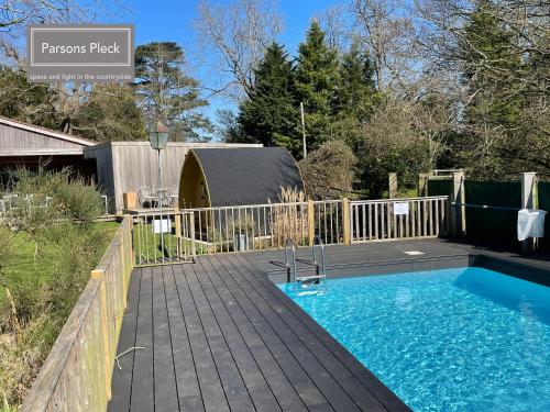 a swimming pool on a deck next to a fence at A rural retreat with space and light in Birlingham