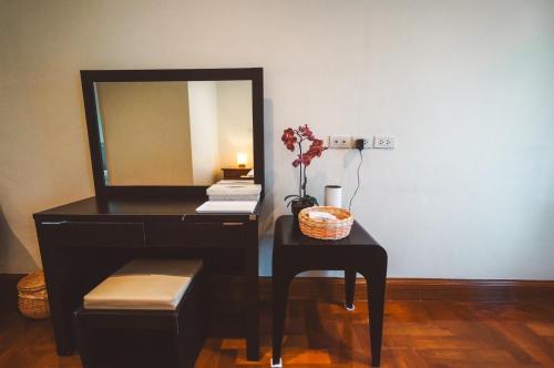 a vanity with a mirror and a table with a stool at Chez Moi Bangkok Private Executive Residence Sukhumvit 26 in Khlong Toei