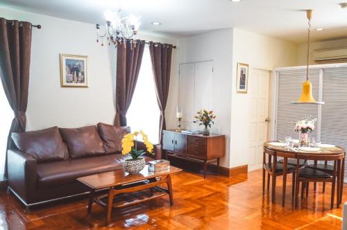 a living room with a couch and a table at Chez Moi Bangkok Private Executive Residence Sukhumvit 26 in Khlong Toei