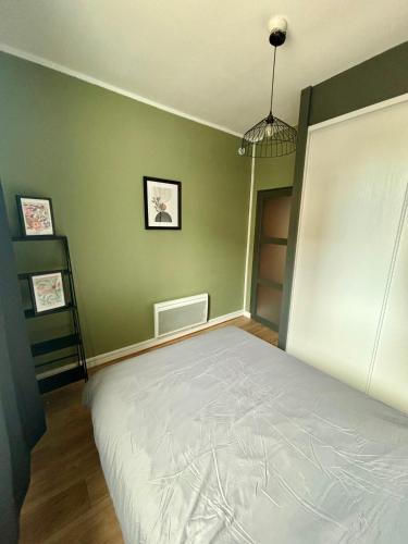 une chambre avec un lit et un mur végétal dans l'établissement Appartement proche gare avec garage, à Rouen