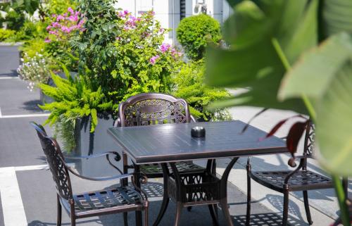 a black table and two chairs and some flowers at Wellstay Hotel in Jianyang