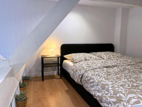 une chambre avec un lit et une table avec une lampe dans l'établissement Studio cocon aux portes de PARIS, à Saint-Maur-des-Fossés