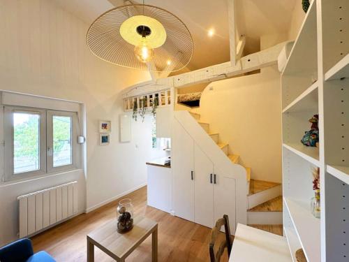 un salon avec un escalier et une table dans l'établissement Studio cocon aux portes de PARIS, à Saint-Maur-des-Fossés
