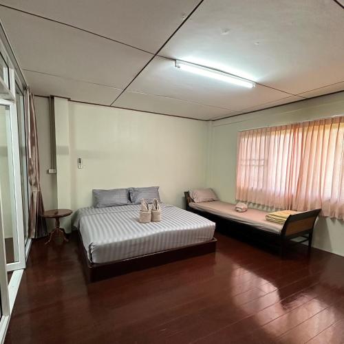 a room with two beds and a window at Hatyai house 28 in Hat Yai