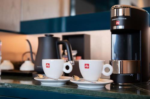 two coffee cups on a counter next to a coffee maker at The Westin Miyako Kyoto in Kyoto