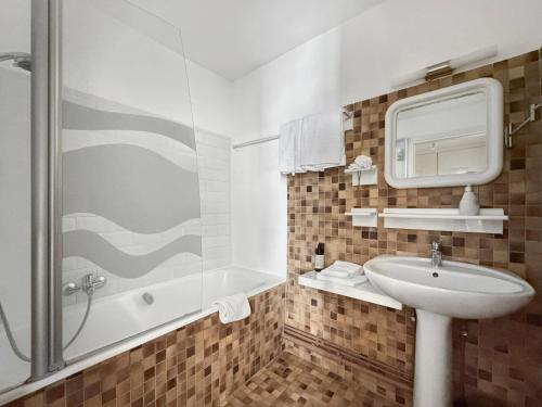 une salle de bain blanche avec un lavabo et une douche dans l'établissement B&B by Jo, à Colmar