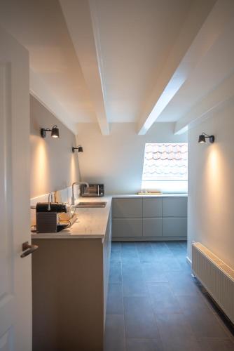 a kitchen with white counters and a window at Amersfoort City Center Apartment StadsHart in Amersfoort