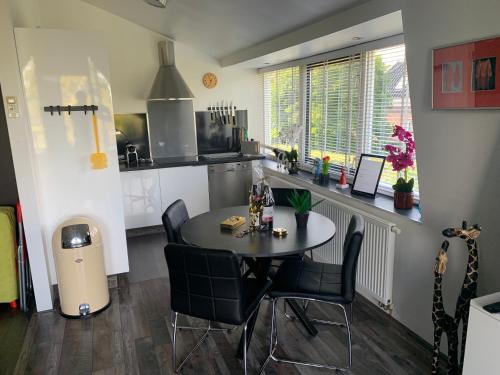 a kitchen with a table and chairs in a room at Amsterdam Countryside met Airco ,Geweldig uitzicht, luxe keuken,wasmachine,droger,gratis fietsen in Den Ilp