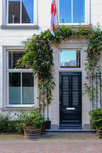 a black door on a white house with plants at Amersfoort City Center Apartment StadsHart in Amersfoort