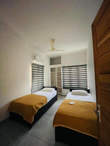 two beds in a room with two windows at Jwel homes inn in Ernakulam