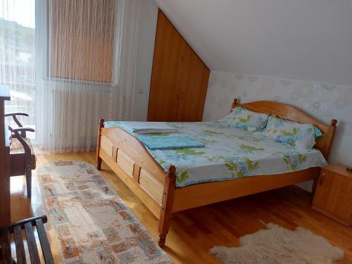 a bedroom with a bed and a large window at Casuta dintre dealuri in Vlădeşti