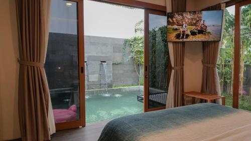 a bedroom with a view of a swimming pool at Villa Di Bali in Jetis