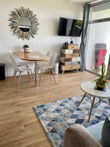 a dining room with a table and chairs and a mirror at Appartement Belles Vacances in Quiberon