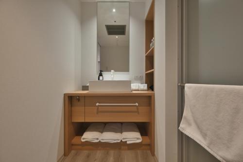 a bathroom with a sink and a mirror at Prince Smart Inn Osaka Yodoyabashi in Osaka