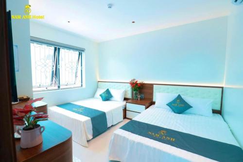 a hotel room with two beds and a window at Nam Anh Hotel Lai Châu in Lai Châu
