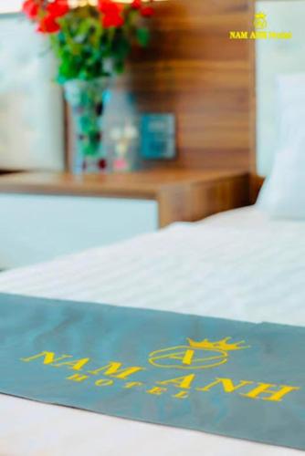 a sign on a bed with yellow writing on it at Nam Anh Hotel Lai Châu in Lai Châu