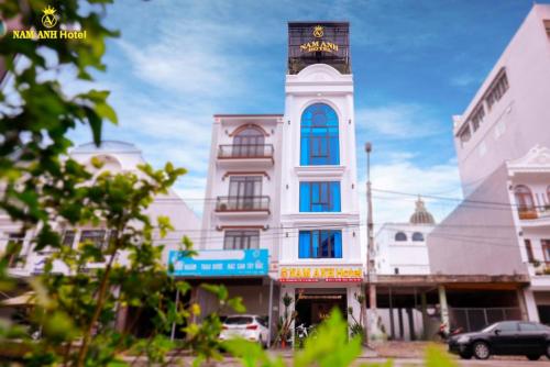 a tall white building with a clock tower on it at Nam Anh Hotel Lai Châu in Lai Châu