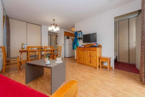 un salon avec une table et une cuisine dans l'établissement Résidence Goélia Le Blanchot, à Pralognan-la-Vanoise