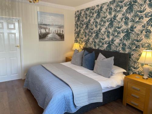 ein Schlafzimmer mit einem Bett mit einer blau-weißen Decke in der Unterkunft Roker Cottage, luxury seaside apartment, private parking, sky tv in Sunderland