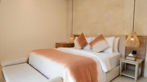 a bedroom with a large white bed with pillows at Villa Di Bali in Jetis