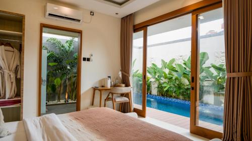 a bedroom with a bed and a view of a pool at Villa Di Bali in Jetis