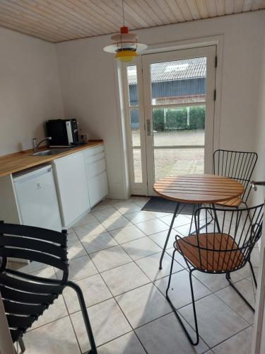 a kitchen with a table and two chairs and a table at 55Tørring in Tørring