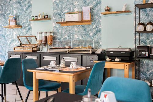 a dining room with blue chairs and a table at Deltour Hotel Le Puy En Velay in Le Puy en Velay
