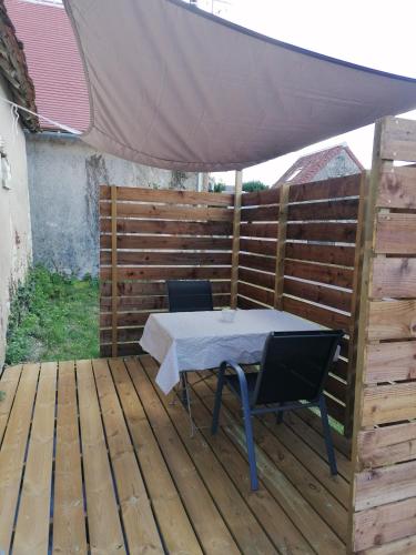 a table and chairs under an umbrella on a deck at Maison ancienne in Azay-le-Ferron