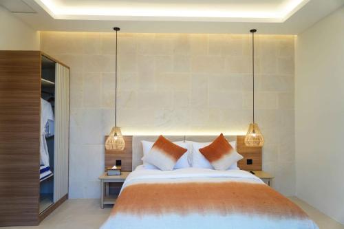 a bedroom with a large bed with two lamps at Villa Di Bali in Jetis