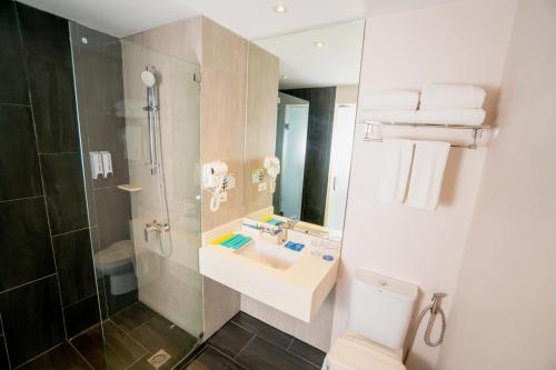 a bathroom with a sink and a shower at Solea Mactan Resort in Mactan
