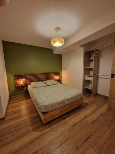 a bedroom with a bed and a wooden floor at Charmante maison de ville in Châtillon-sur-Seine