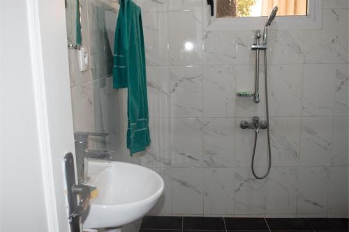a bathroom with a shower with a toilet and a sink at Appartement Prestige Avec Balcon in Pointe-Noire