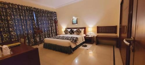 a hotel room with a bed and a window at ASHOKA INN in Trichūr