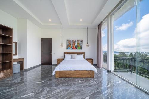 a bedroom with a bed and a large window at Adara Lake View Residence Bedugul - Bali in Bedugul