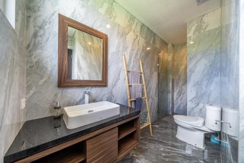 a bathroom with a sink and a toilet at Adara Lake View Residence Bedugul - Bali in Bedugul