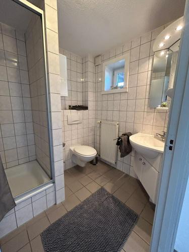 a bathroom with a toilet and a sink and a shower at Pension Stral-Sund UG in Stralsund