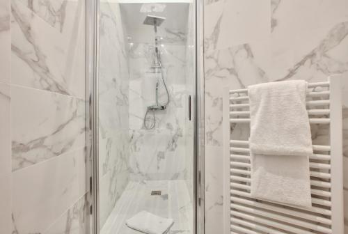 une salle de bain blanche avec douche et toilettes dans l'établissement 64 - Urban Luxury Flat near Champs-Elysees, à Paris
