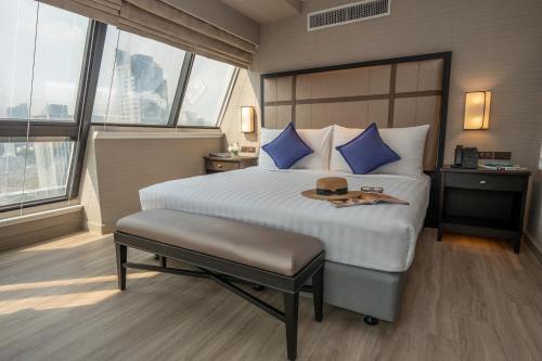 a bedroom with a large bed with a hat on it at NH Bangkok Sukhumvit Boulevard in Bangkok