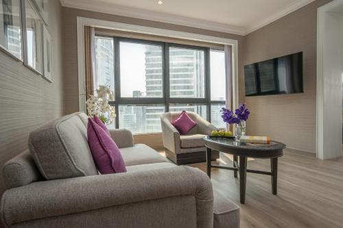 a living room with a couch and a table at NH Bangkok Sukhumvit Boulevard in Bangkok