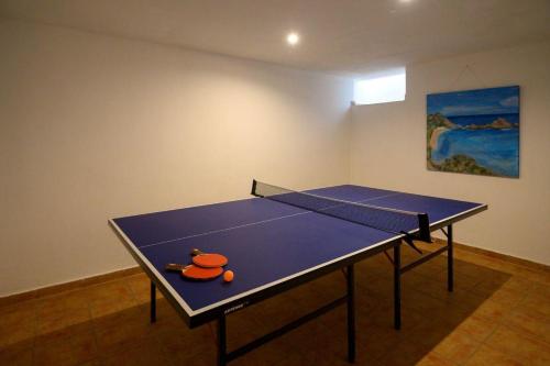 a ping pong table in a room with a ping pong racket at Villa Sa Calma in Port d'Addaia
