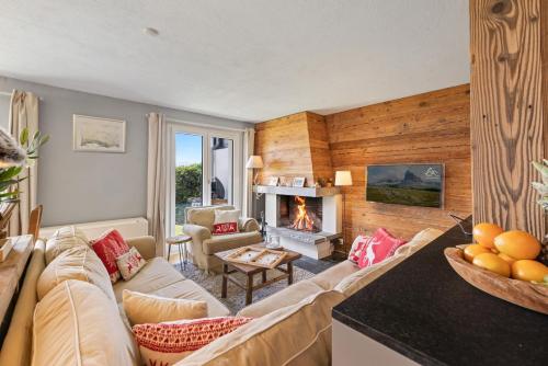 a living room with a couch and a fireplace at Cabane de la Delege -Crans Montana- Amazing Views in Crans-Montana