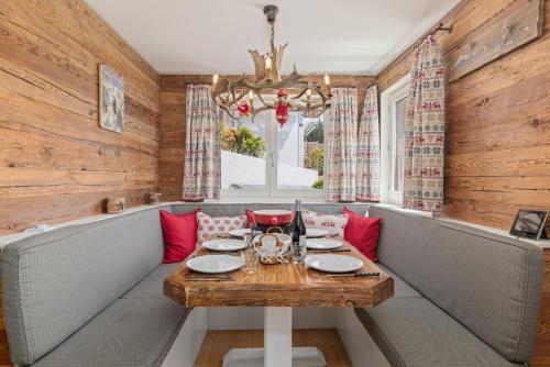 a dining room with a table and a chandelier at Cabane de la Delege -Crans Montana- Amazing Views in Crans-Montana