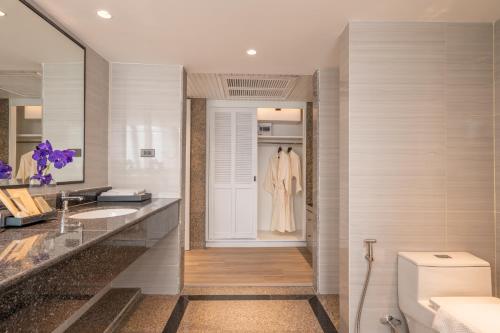 a bathroom with a toilet and a sink at NH Bangkok Sukhumvit Boulevard in Bangkok